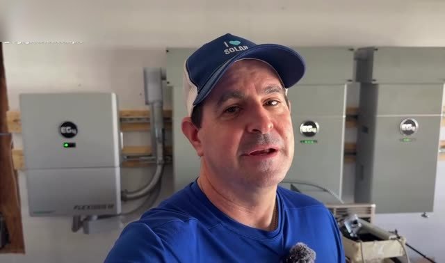 Original: landscape video of a man in front of solar battery cabinets